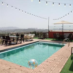 a swimming pool with a ball in the middle of it at Spruce Peak Villa in Mumbai
