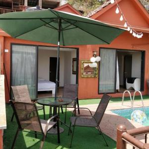 孟買的住宿－Spruce Peak Villa，庭院配有桌椅和遮阳伞。