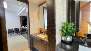 a bathroom with a sink and a mirror and a desk at Guangzhou Xing Yi International Apartment - Poly World Branch in Guangzhou