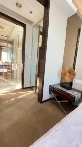a room with a bed and a mirror and a fan at Guangzhou Xing Yi International Apartment - Poly World Branch in Guangzhou