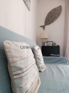 sypialnia z łóżkiem z poduszkami w obiekcie Appartement Romantic Sea w mieście Le Barcarès