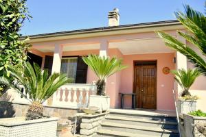 a pink house with palm trees in front of it at Casa della Genovina in Capodimonte