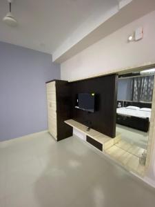 Zimmer mit einem Bett und einem TV. in der Unterkunft Dhanya Lodge in Padubidri