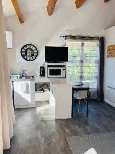 a kitchen with a table and a clock on the wall at Charmante maisonnette 4pers in Canet