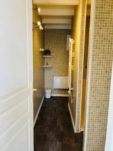 a bathroom with a toilet in a room with yellow tiles at Charmante maisonnette 4pers in Canet