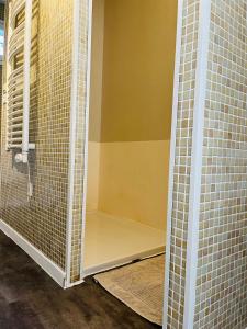 y baño con ducha y paredes de azulejos. en Charmante maisonnette 4pers en Canet
