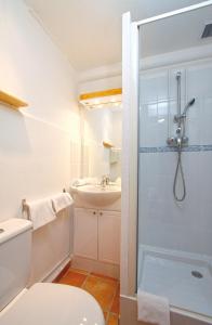 a bathroom with a shower and a toilet and a sink at Hôtel La Croix de Malte in La Ciotat