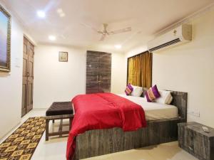 een slaapkamer met een bed met een rode deken bij Shore Beats Villa in Mumbai