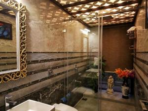 a bathroom with a glass shower and a sink at Shore Beats Villa in Mumbai