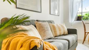 a living room with a couch with a blanket on it at Mullum Haven 3 - Central & Stylish Townhouse in Mullumbimby
