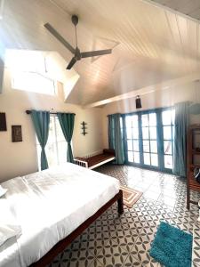 a bedroom with a bed and a ceiling fan at KAAYAMKAAD - FOREST DWELLINGS COORG in Madikeri