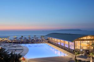 Arina Beach Resort في كوكيني خانيون: مسبح كبير في المنتجع بالليل