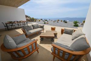 a patio with chairs and a couch and a table at Dream Cave Villa Tinos in Tinos Town