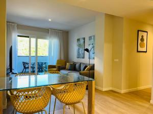 sala de estar con mesa de cristal y sillas en Wellingtonia Lujoso apart con piscina y parking en Estepona