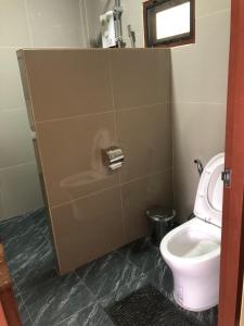 een badkamer met een toilet en een toiletpapierdispenser bij บ้านอยู่ดีโฮมสเตย์ 