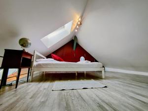 een zolderkamer met een bed en een trap bij Home - Sous les toits de Paris - Séjour à Auxerre in Auxerre