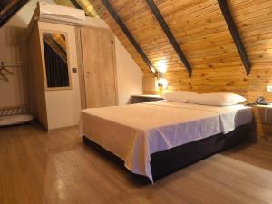 a bedroom with a bed in a wooden room at Motto Wood Otel in Hatay