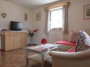 a living room with a coffee table and a tv at Ferienwohnung Grüsser-kagerhuber in Schönau am Königssee
