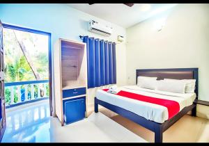 a bedroom with a bed and a balcony at Calangute Turista in Calangute