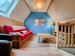 a living room with a red couch and a blue wall at Chez Maméta - Séjour à Auxerre in Auxerre