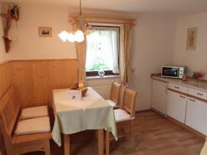 a kitchen with a table and chairs and a window at Ferienwohnung Grüsser-kagerhuber in Schönau am Königssee
