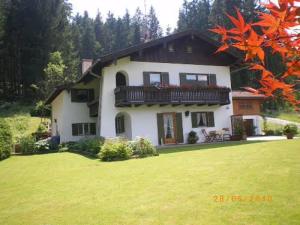 a large white house with a balcony on a yard at Ferienwohnung Grüsser-kagerhuber in Schönau am Königssee