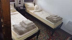 2 Betten in einem Zimmer mit Handtüchern darauf in der Unterkunft Къща за гости -Абаджиевата къща in Kotel