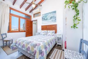a bedroom with a bed and a window at Poppy's Beach House in Colònia De Sant Jordi