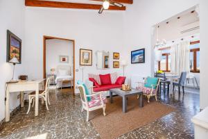 a living room with a red couch and chairs at Poppy's Beach House in Colònia De Sant Jordi