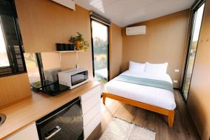 a small bedroom with a bed and a tv at Rimu View 2 by Tiny Away in Hokitika