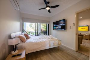 sypialnia z łóżkiem i wentylatorem sufitowym w obiekcie Deluxe 2-Bed Unit with Parking and Outdoor Area w mieście Brisbane