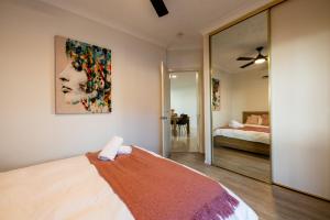 a bedroom with a bed with a painting on the wall at Deluxe 2-Bed Unit with Parking and Outdoor Area in Brisbane