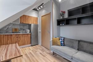 a living room with a couch and a kitchen at Stay Express Hotel in Vilnius