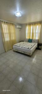 a bedroom with a bed in a room with windows at villa nikiboko Bonaire in Kralendijk