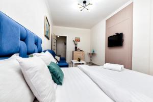 1 dormitorio con 1 cama blanca grande y cabecero azul en Luxurious apartment in the heart of Astana, en Astana