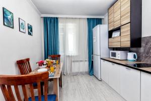 una pequeña cocina con mesa y nevera en Luxurious apartment in the heart of Astana, en Astana