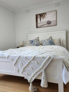 Cama blanca con edredón y almohadas blancos en Meadow View Cottage en Doveton