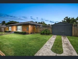 un patio con una casa de ladrillo y una valla en Meadow View Cottage, en Doveton