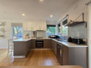 cocina con electrodomésticos de acero inoxidable y suelo de madera en Meadow View Cottage, en Doveton