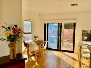 una sala da pranzo con tavolo e vaso di fiori di Stellar Suite a Woodville South