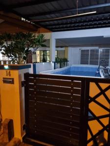 Chemor的住宿－PRIVATE POOL Ssue Klebang Ipoh Homestay-Guesthouse With Wifi & Netflix，一座带黑色围栏的建筑中的游泳池