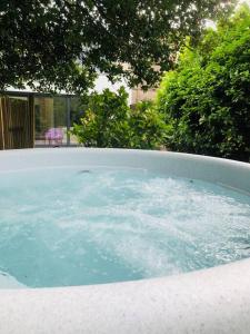 a hot tub with blue water in a yard at Keppochhill - Beautiful Home with Hot Tub in Dullatur