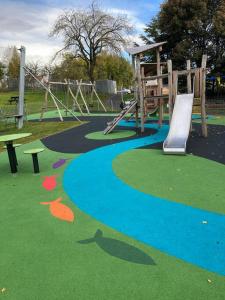 a playground with a slide in a park at Keppochhill - Beautiful Home with Hot Tub in Dullatur