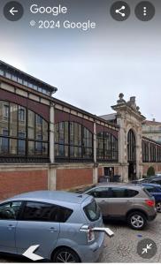 deux voitures garées sur un parking devant un immeuble dans l'établissement Les halles de Béziers, à Béziers