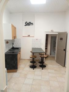 une cuisine avec une table et des tabourets dans une pièce dans l'établissement Les halles de Béziers, à Béziers