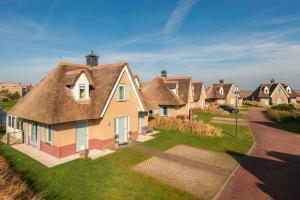 a row of houses with a thatched roof at Dormio Villapark Duynzicht in Julianadorp