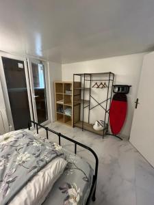Schlafzimmer mit einem Bett und einem roten Kühlschrank in der Unterkunft Logement entier limay in Limay