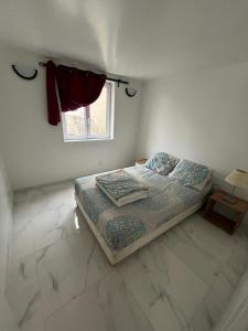 a small bedroom with a bed and a window at Logement entier limay in Limay