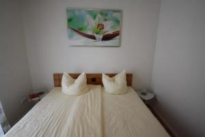 ein Bett mit zwei Kissen auf einem Zimmer in der Unterkunft K 95 - Modernes Ferienhaus mit Kamin in Roebel an der Mueritz in Marienfelde