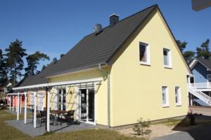 une maison blanche avec un toit noir dans l'établissement K 97 - stilvolles Ferienhaus mit Kamin & WLAN am See in Röbel an der Müritz, à Röbel